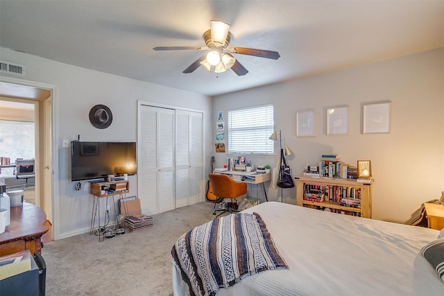 bedroom featuring ceiling fan, light carpet, and a closet