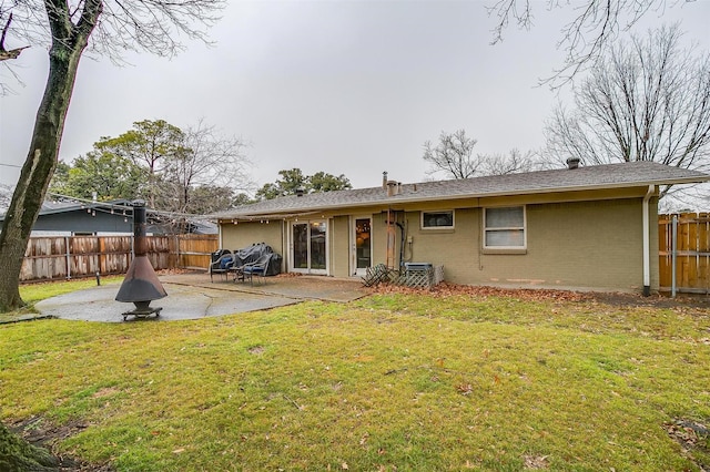 back of house featuring a lawn and a patio