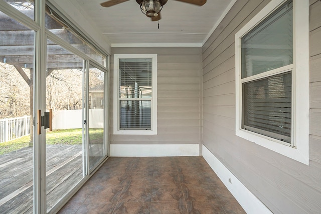 unfurnished sunroom with ceiling fan