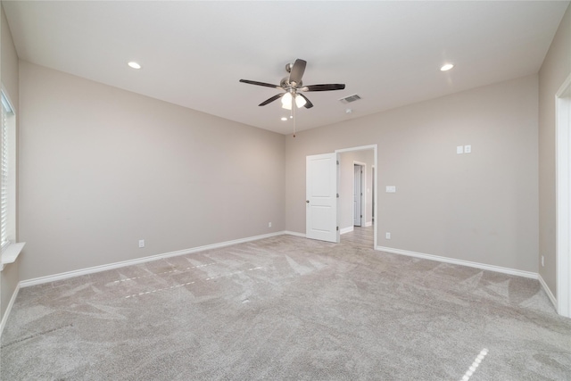 spare room featuring light carpet and ceiling fan