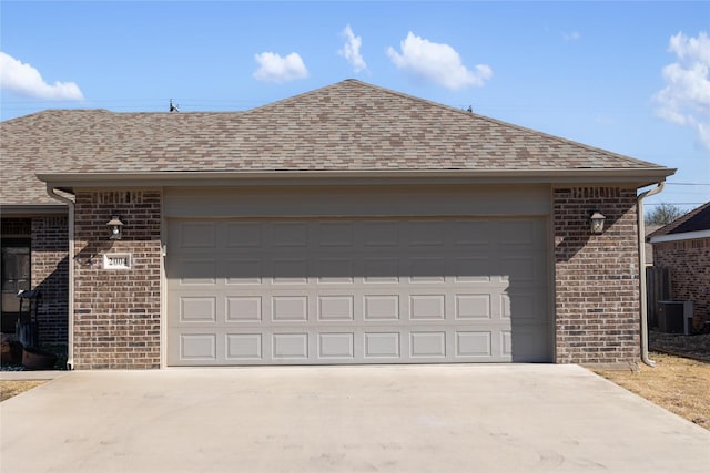 view of front of home featuring a garage, an outbuilding, and central AC unit