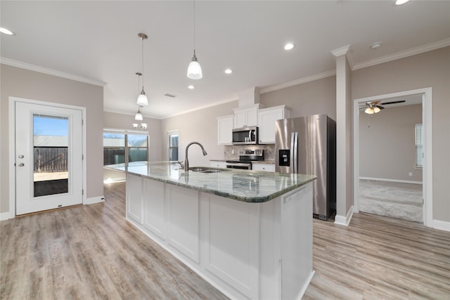 kitchen with sink, decorative light fixtures, a center island with sink, appliances with stainless steel finishes, and white cabinets