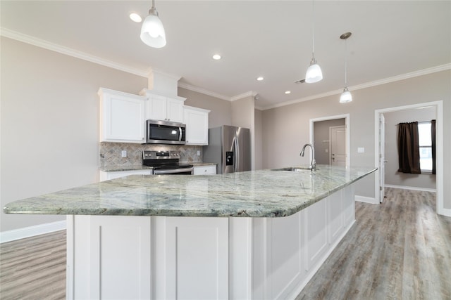 kitchen with pendant lighting, a large island, white cabinets, and appliances with stainless steel finishes