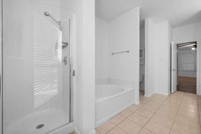 bathroom featuring tile patterned flooring, toilet, and separate shower and tub