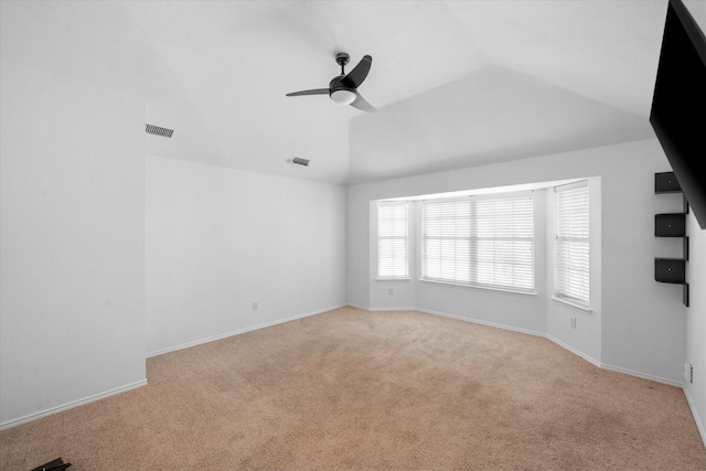 empty room featuring ceiling fan, light colored carpet, and vaulted ceiling