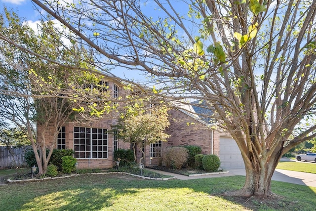 view of property hidden behind natural elements featuring a garage and a front yard