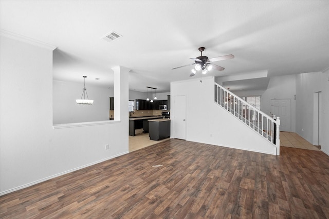 unfurnished living room with hardwood / wood-style flooring and ceiling fan with notable chandelier