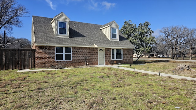 cape cod home featuring a front lawn