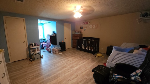 bedroom with a textured ceiling and light hardwood / wood-style floors