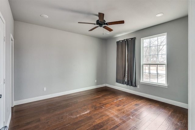 empty room featuring ceiling fan, plenty of natural light, and dark hardwood / wood-style flooring