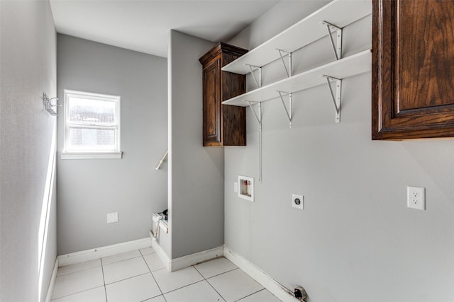 laundry area featuring cabinets, light tile patterned floors, hookup for a washing machine, and electric dryer hookup