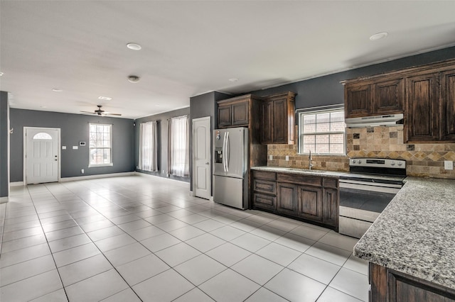 kitchen featuring sink, light tile patterned floors, appliances with stainless steel finishes, a wealth of natural light, and decorative backsplash