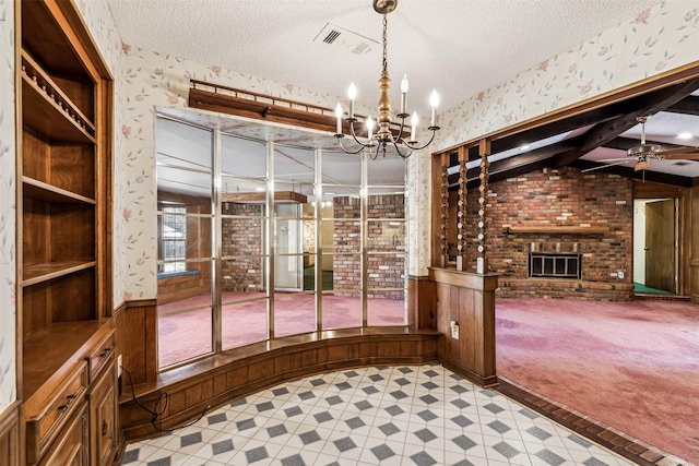 wine room featuring lofted ceiling with beams, light carpet, a textured ceiling, a fireplace, and ceiling fan with notable chandelier