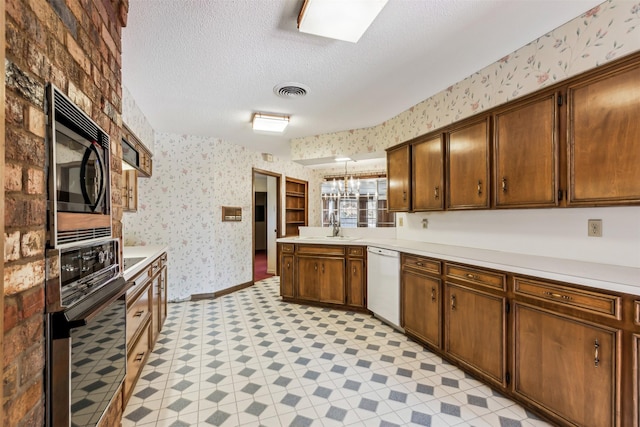 kitchen with sink, a chandelier, hanging light fixtures, a textured ceiling, and black appliances