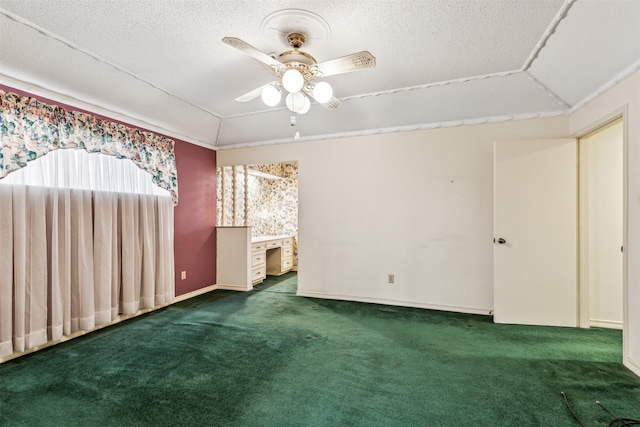 empty room featuring ceiling fan, dark carpet, and a textured ceiling