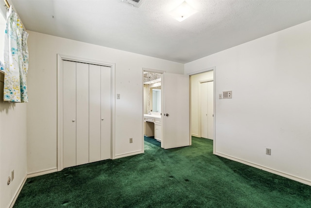 unfurnished bedroom featuring dark colored carpet, a textured ceiling, and a closet