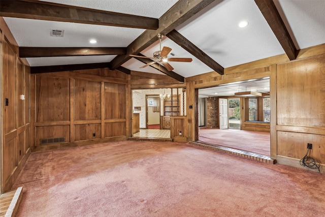 unfurnished living room featuring carpet floors, lofted ceiling with beams, a textured ceiling, and wood walls