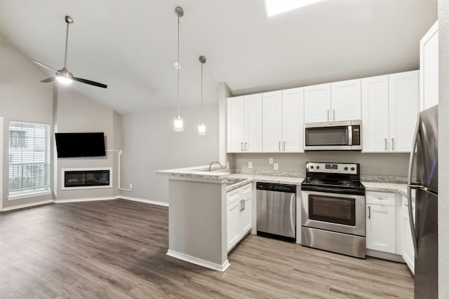 kitchen with pendant lighting, kitchen peninsula, white cabinets, and appliances with stainless steel finishes