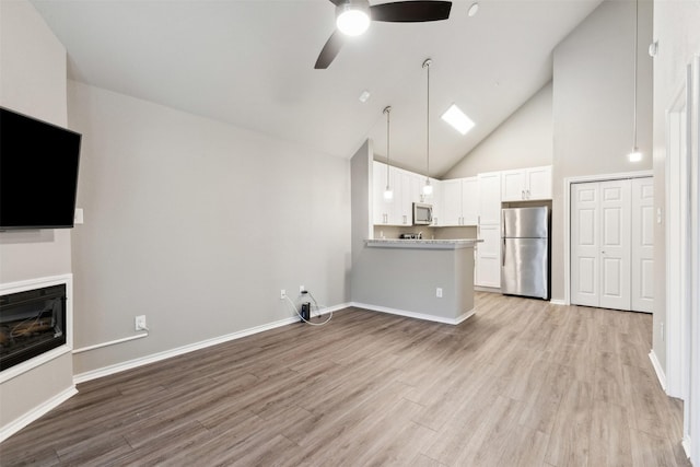 unfurnished living room featuring ceiling fan, high vaulted ceiling, and light hardwood / wood-style flooring