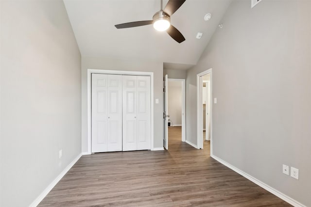 unfurnished bedroom with lofted ceiling, hardwood / wood-style floors, a closet, and ceiling fan