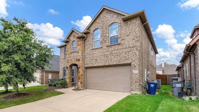 view of front of home featuring concrete driveway, stone siding, an attached garage, fence, and a front lawn