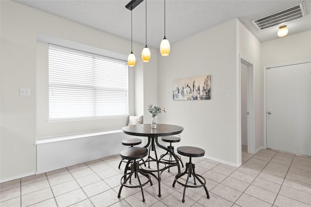 dining area featuring a textured ceiling and light tile patterned flooring