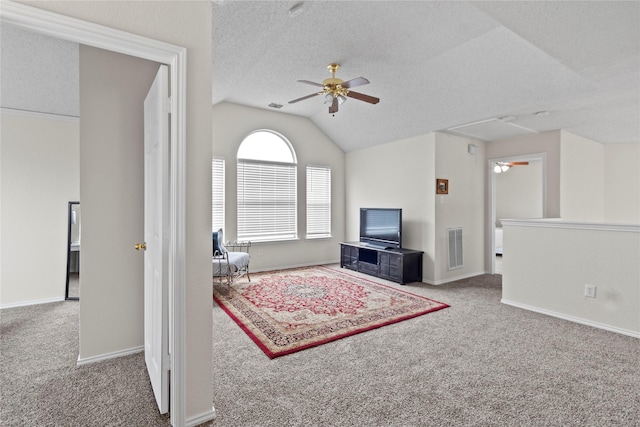 carpeted living room with ceiling fan, lofted ceiling, and a textured ceiling