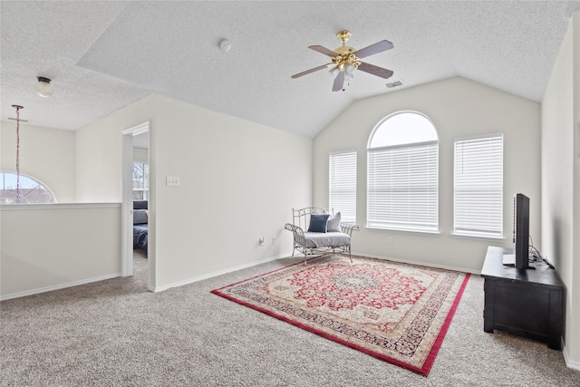 sitting room featuring ceiling fan, plenty of natural light, vaulted ceiling, and carpet flooring