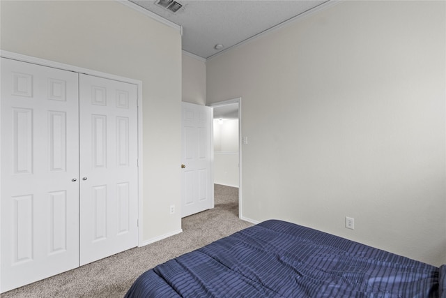 carpeted bedroom featuring crown molding and a closet