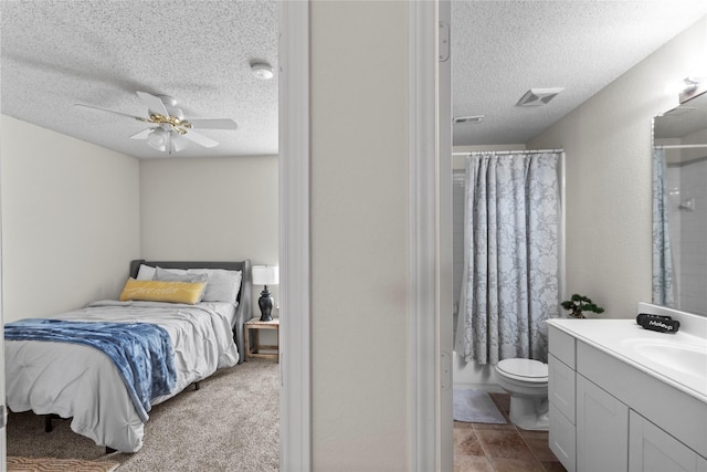 bedroom with ceiling fan, sink, connected bathroom, and a textured ceiling