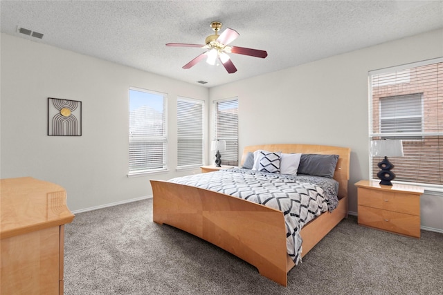 bedroom with ceiling fan, carpet floors, and a textured ceiling