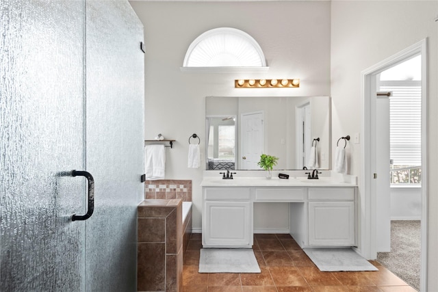 bathroom with vanity, a bathtub, plenty of natural light, and tile patterned floors