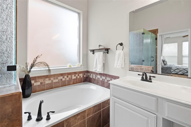 bathroom with vanity and shower with separate bathtub