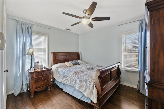 bedroom featuring multiple windows, dark hardwood / wood-style floors, and ceiling fan