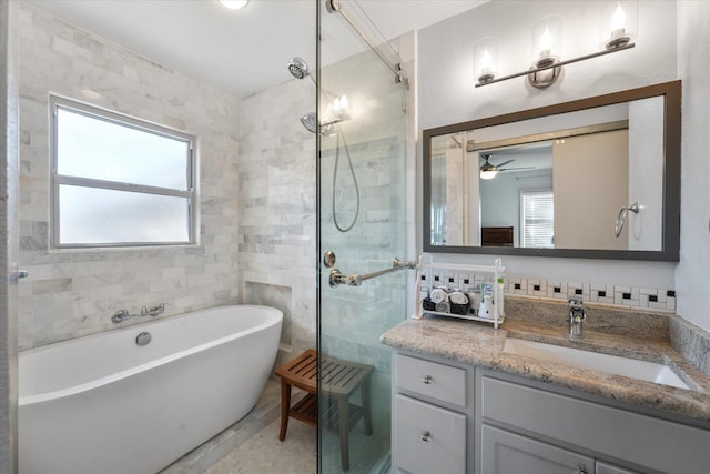 bathroom featuring plenty of natural light, independent shower and bath, tile walls, and vanity