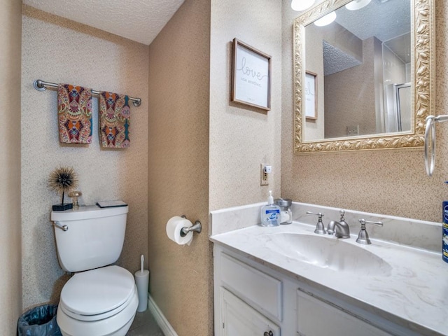 bathroom featuring vanity, a textured ceiling, and toilet