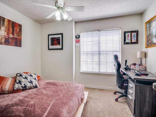 bedroom featuring ceiling fan, light colored carpet, and a textured ceiling