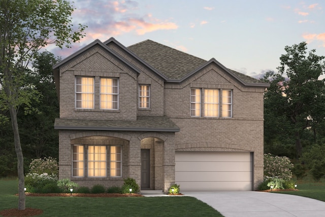 view of front of property featuring a yard and a garage