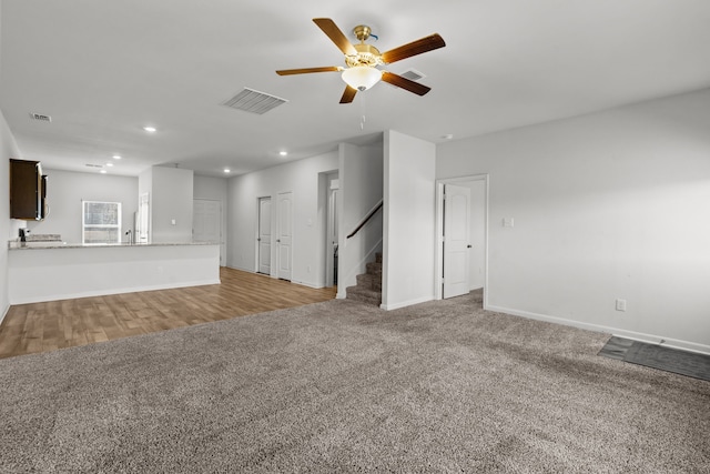 unfurnished living room with ceiling fan and light carpet