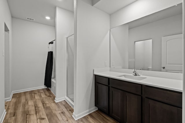 bathroom featuring vanity, hardwood / wood-style flooring, and shower with separate bathtub