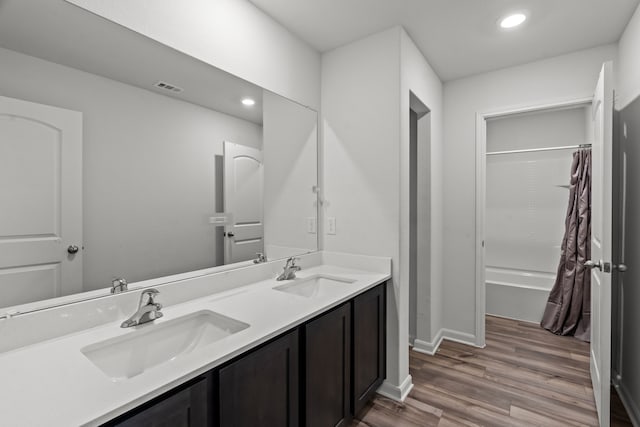 bathroom with vanity, hardwood / wood-style flooring, and shower / bath combo with shower curtain