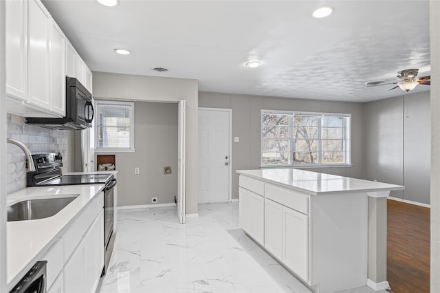 kitchen featuring decorative backsplash, a healthy amount of sunlight, stainless steel range with electric cooktop, and white cabinets