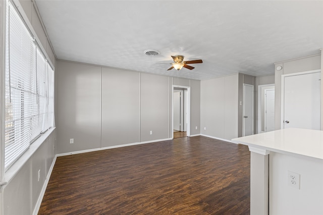 unfurnished living room with dark hardwood / wood-style floors and ceiling fan