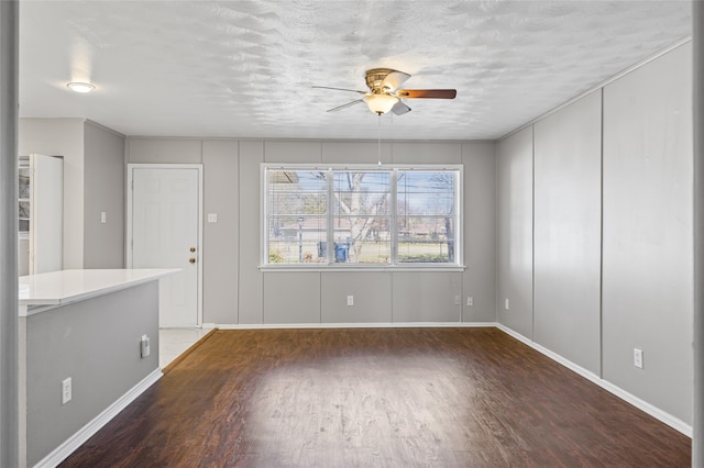 spare room featuring dark hardwood / wood-style floors, a textured ceiling, and ceiling fan