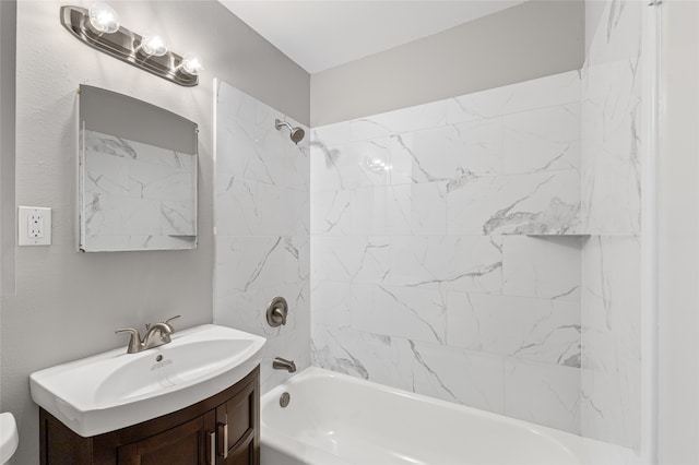 bathroom with tiled shower / bath and vanity