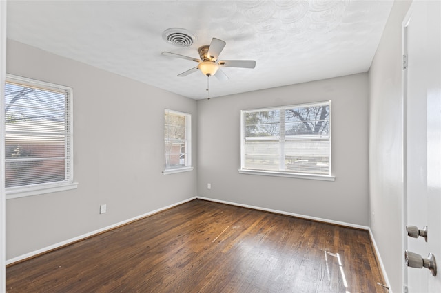 spare room with ceiling fan and dark hardwood / wood-style flooring