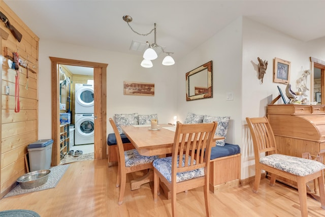 dining room featuring stacked washer and clothes dryer and light wood-type flooring