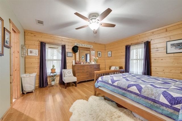 bedroom featuring wooden walls and light hardwood / wood-style flooring