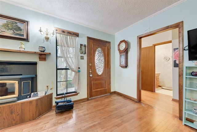 entrance foyer with crown molding, light hardwood / wood-style floors, and a textured ceiling