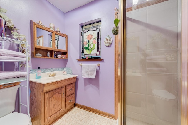 bathroom featuring vanity, toilet, and a shower with shower door